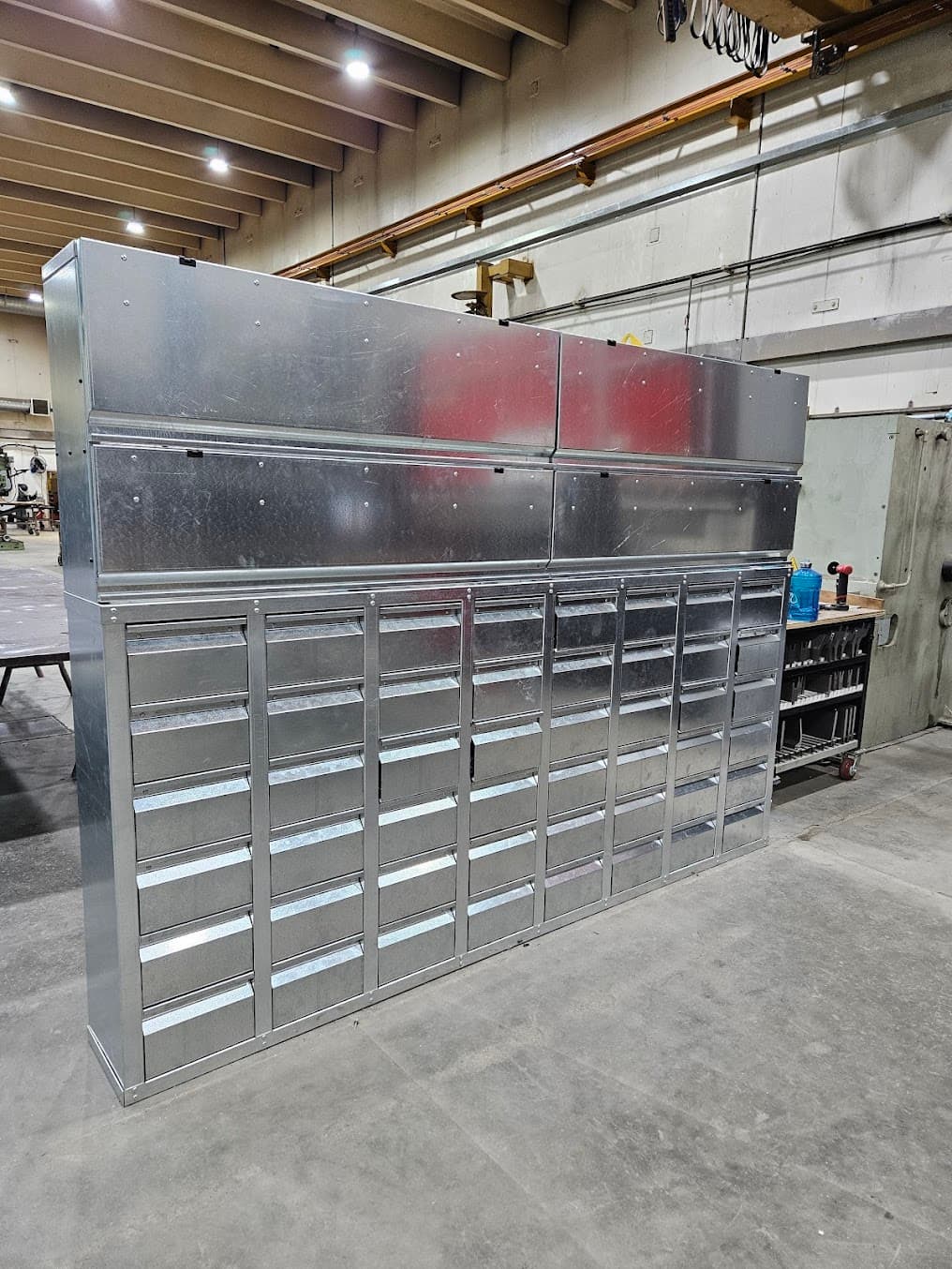 A large, tall galvanized metal cabinet with multiple drawers and upper compartments, likely for storage in a workshop.